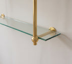 Close-up of a solid brass ball joint and wall flange supporting a 10 mm glass shelf