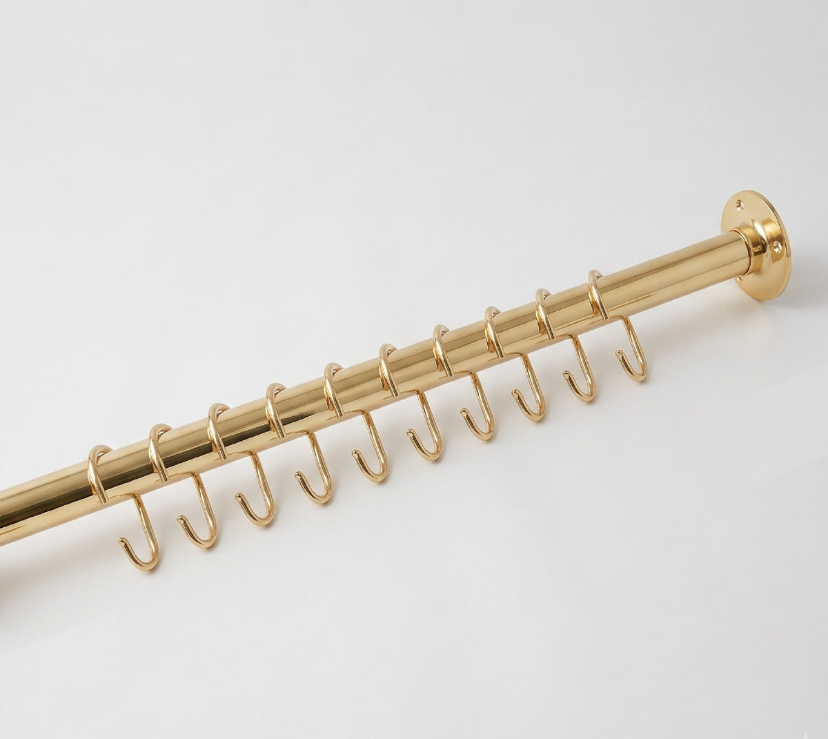 Close-up of a solid brass wall flange on the wall-to-wall shower rod with curtain hooks