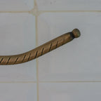 Detail of the engraved pattern on a brass toilet paper holder